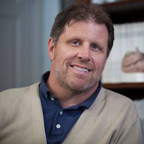 Brick Johnstone in an office with a bookshelf in the background